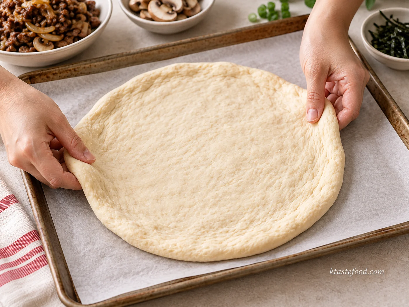 Refrigerated pizza dough being gently stretched on a lined baking sheet for Korean bulgogi pizza