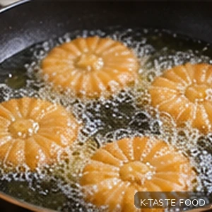 Yakgwa cookies slowly frying to golden brown in a pot of oil