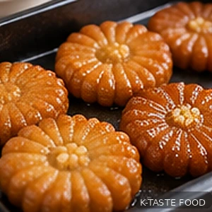 Golden fried yakgwa draining excess oil on a wire rack