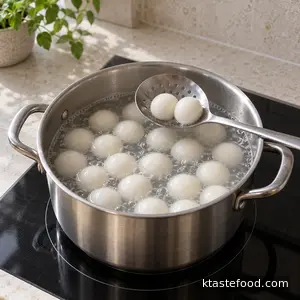 Sweet rice balls floating in gently boiling water in a separate saucepan