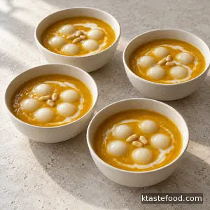 Finished creamy hobakjuk served in four small bowls with rice balls and pine nuts