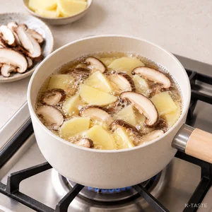 Thin potato slices and shiitake mushrooms simmering in tuna-seasoned broth